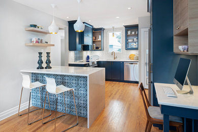 Trendy l-shaped light wood floor eat-in kitchen photo in Ottawa with blue cabinets, quartz countertops and an island