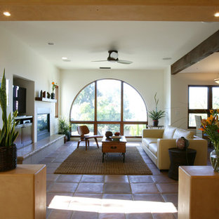 Mittelgroßes, Offenes, Repräsentatives Mediterranes Wohnzimmer mit bunten Wänden, Terrakottaboden, Kamin, verputztem Kaminsims, Multimediawand und rotem Boden in Orange County