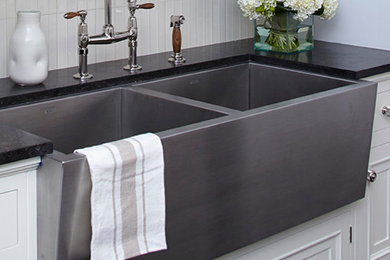 Example of a farmhouse kitchen design in Vancouver with a farmhouse sink, white cabinets, solid surface countertops, white backsplash and ceramic backsplash