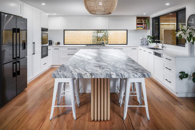 Design ideas for a traditional grey and white kitchen in Perth with a submerged sink, shaker cabinets, white cabinets, granite worktops, white splashback, metro tiled splashback, black appliances, medium hardwood flooring, an island and grey worktops.