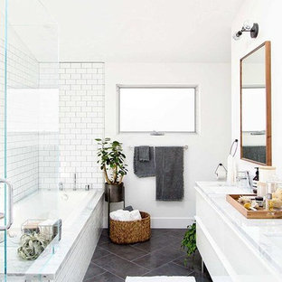 Danish white tile and subway tile slate floor and gray floor bathroom photo in Miami with flat-panel cabinets, white cabinets, white walls, an undermount sink, marble countertops and a hinged shower door