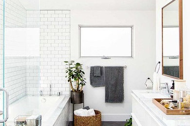 Danish white tile and subway tile slate floor and gray floor bathroom photo in Miami with flat-panel cabinets, white cabinets, white walls, an undermount sink, marble countertops and a hinged shower door