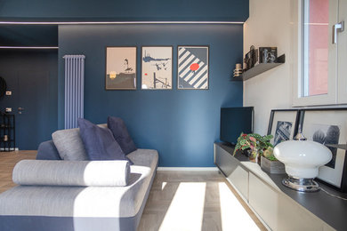 Foto di un soggiorno design di medie dimensioni e aperto con pareti blu, parquet chiaro, TV autoportante e pavimento grigio