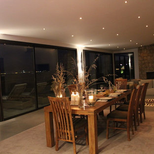 コルシカの広いビーチスタイルのLDKの画像 (白い壁、コンクリートの床、標準型暖炉、石材の暖炉まわり)