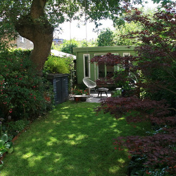 Curving back garden with office and swing