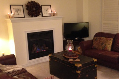 Inspiration for a small transitional enclosed carpeted living room remodel in Toronto with beige walls, a standard fireplace, a plaster fireplace and a tv stand