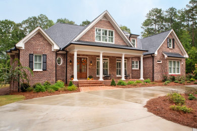 Example of a large classic red two-story brick house exterior design in Other