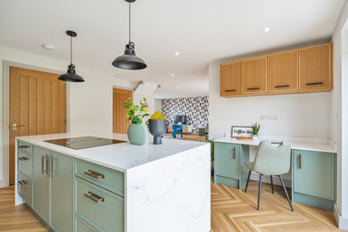 Design ideas for a large modern single-wall open plan kitchen in Other with a built-in sink, green cabinets, marble worktops, black appliances, laminate floors, an island, brown floors, grey worktops and feature lighting.
