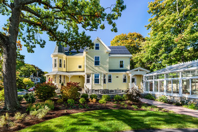Inspiration for a large victorian yellow three-story concrete fiberboard and clapboard exterior home remodel in Boston with a shingle roof and a gray roof
