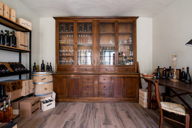 Immagine di un armadio o armadio a muro unisex rustico di medie dimensioni con ante di vetro, ante in legno bruno, pavimento con piastrelle in ceramica e pavimento marrone