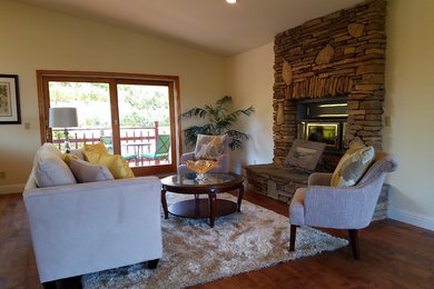 Photo of a mid-sized transitional formal open concept living room in Sacramento with beige walls, medium hardwood floors, a standard fireplace, a stone fireplace surround, no tv and brown floor.