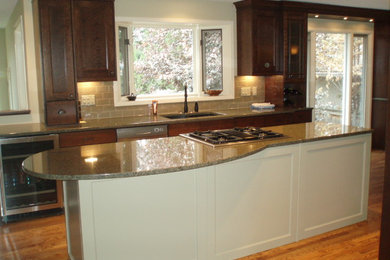 Inspiration for a mid-sized single-wall medium tone wood floor open concept kitchen remodel in Calgary with a double-bowl sink, recessed-panel cabinets, dark wood cabinets, granite countertops, gray backsplash, glass tile backsplash, stainless steel appliances and an island