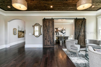 Diseño de salón abierto de estilo americano grande con paredes beige, suelo de madera en tonos medios y suelo marrón