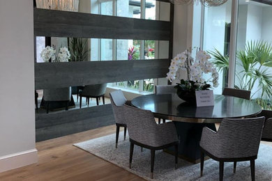 Example of a transitional medium tone wood floor, tray ceiling and wood wall great room design in Miami with gray walls