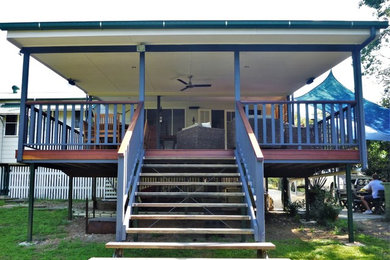 This is an example of a mid-sized traditional backyard deck in Brisbane with an outdoor kitchen and a roof extension.
