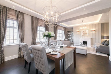 Example of a mid-sized transitional dark wood floor great room design in West Midlands with gray walls, a standard fireplace and a stone fireplace