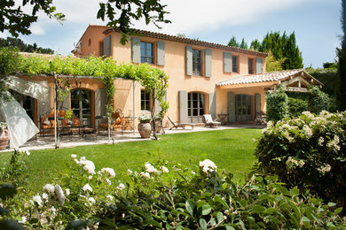 Aménagement d'une façade de maison méditerranéenne à un étage avec un toit à deux pans et un toit en tuile.