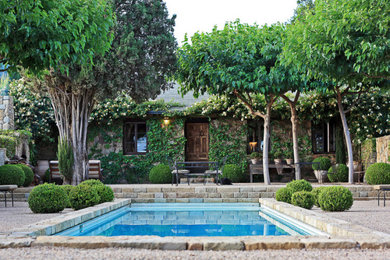Inspiration for a french country privacy front yard stone fence formal garden in Santa Barbara.