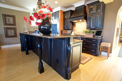 Eat-in kitchen - mid-sized traditional galley bamboo floor eat-in kitchen idea in Other with raised-panel cabinets, black cabinets, mosaic tile backsplash, stainless steel appliances and an island