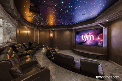 Large country open concept home theatre in Salt Lake City with brown walls, carpet and a projector screen.