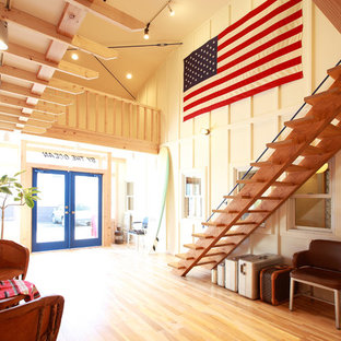 他の地域のビーチスタイルのおしゃれな玄関 (白い壁、無垢フローリング、茶色い床) の写真