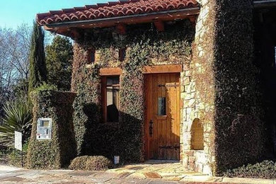 Large tuscan brown stone exterior home photo in Other with a shingle roof