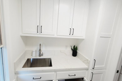 Farmhouse laundry room photo in Los Angeles with white walls and a side-by-side washer/dryer