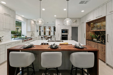 Inspiration for a large modern u-shaped open concept kitchen remodel in San Diego with flat-panel cabinets, white cabinets, wood countertops and an island