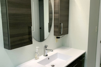 Bathroom - mid-sized modern 3/4 white floor and single-sink bathroom idea in Milwaukee with flat-panel cabinets, dark wood cabinets, a two-piece toilet, green walls, an integrated sink, white countertops and a floating vanity