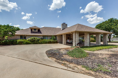 Mid-sized elegant beige one-story stone exterior home photo in Dallas with a clipped gable roof