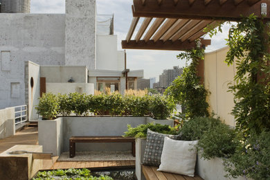 Photo of a large traditional rooftop full sun garden in New York with a water feature and decking.