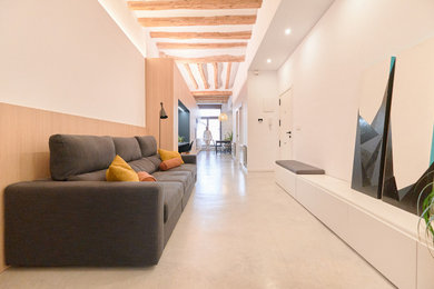 Diseño de salón moderno sin televisor con paredes blancas, suelo de cemento y vigas vistas