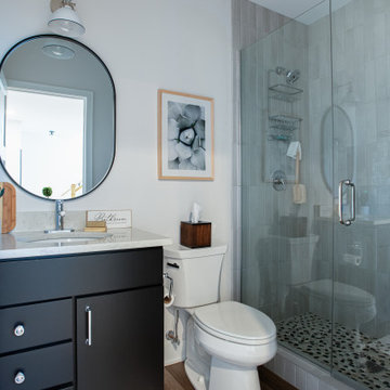 Modern Basement Bathroom with Dark Charcoal Vanity & Pill-Shaped Mirror