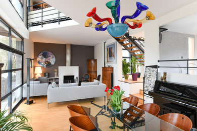 Idée de décoration pour une très grande salle à manger design avec un mur blanc, parquet clair, une cheminée standard, un sol beige et éclairage.
