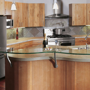 Создайте стильный интерьер: маленькая п-образная кухня в современном стиле с обеденным столом, тройной раковиной, плоскими фасадами, светлыми деревянными фасадами, столешницей из талькохлорита, серым фартуком, фартуком из каменной плитки, техникой из нержавеющей стали, темным паркетным полом и островом - последний тренд