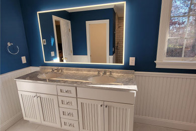 Large classic ensuite bathroom in Boston with beaded cabinets, white cabinets, a built-in shower, blue walls, porcelain flooring, a submerged sink, granite worktops, beige floors, an open shower, a wall niche, double sinks, a freestanding vanity unit and wainscoting.