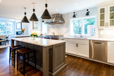 Inspiration for a transitional u-shaped eat-in kitchen in DC Metro with an undermount sink, recessed-panel cabinets, white cabinets, quartzite benchtops, grey splashback, ceramic splashback, stainless steel appliances, medium hardwood floors, with island, brown floor and white benchtop.