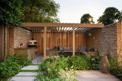 Inspiration for a small contemporary back partial sun garden in London with natural stone paving.