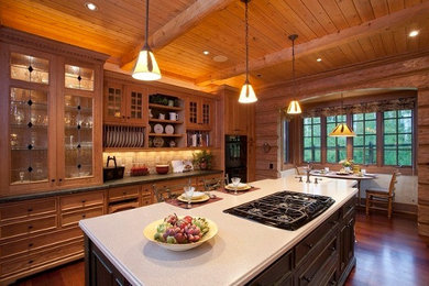 Eat-in kitchen - large rustic medium tone wood floor and brown floor eat-in kitchen idea in Denver with an island, a drop-in sink, recessed-panel cabinets, medium tone wood cabinets, beige backsplash, stone tile backsplash, black appliances and white countertops