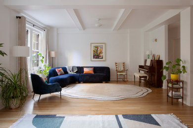 Example of a large trendy open concept light wood floor living room design in New York with a music area, white walls, no fireplace and no tv