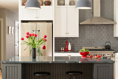 Elegant l-shaped light wood floor eat-in kitchen photo in Boston with shaker cabinets, white cabinets, gray backsplash, subway tile backsplash, stainless steel appliances and an island