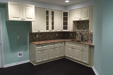 Open concept kitchen - small transitional l-shaped dark wood floor open concept kitchen idea in Atlanta with a double-bowl sink, glass-front cabinets, yellow cabinets, limestone countertops, multicolored backsplash, matchstick tile backsplash and no island