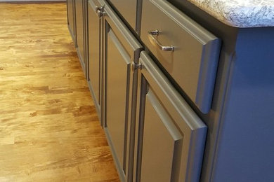 シアトルにある高級な広いモダンスタイルのおしゃれなキッチン (ドロップインシンク、インセット扉のキャビネット、グレーのキャビネット、御影石カウンター、グレーのキッチンパネル、ガラスタイルのキッチンパネル、シルバーの調理設備、無垢フローリング、茶色い床) の写真