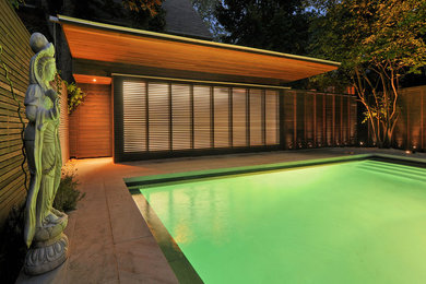 Design ideas for a mid-sized modern backyard rectangular lap pool in Toronto with natural stone pavers.