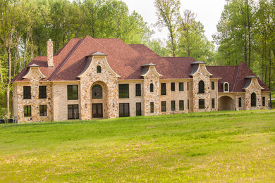 Inspiration for a huge transitional beige three-story stone house exterior remodel in Baltimore with a hip roof and a shingle roof
