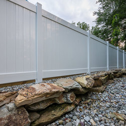 Composite Fence on Boulder Retaining Wall - Home Fencing And Gates