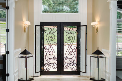 Example of a large trendy wainscoting entryway design in Charlotte with beige walls and a black front door