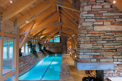 Pool house - large stone and rectangular lap pool house idea in Other