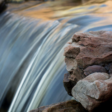 Rustic Mountain stream flowing into lakeside patio