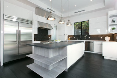 Inspiration for a mid-sized contemporary l-shaped eat-in kitchen in Los Angeles with an undermount sink, flat-panel cabinets, white cabinets, solid surface benchtops, black splashback, ceramic splashback, stainless steel appliances, dark hardwood floors and with island.